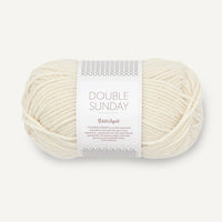 Ball of cream yarn with a label on a white background