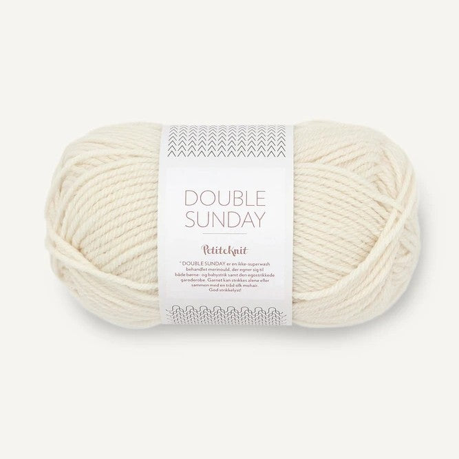 Ball of cream yarn with a label on a white background