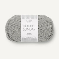 Ball of grey heathered yarn with a label on a white background