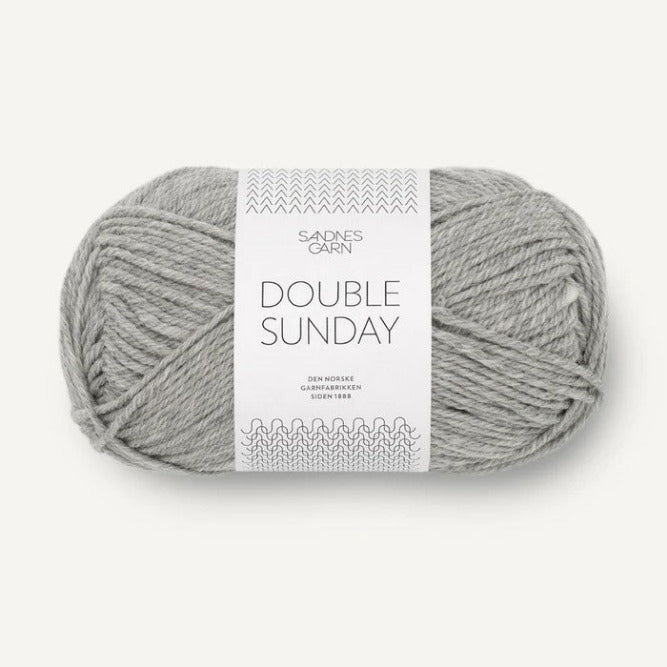 Ball of grey heathered yarn with a label on a white background