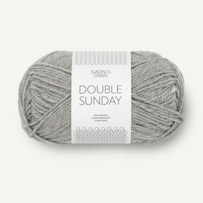 Ball of grey heathered yarn with a label on a white background