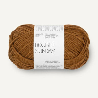 Ball of mustard brown yarn with a label on a white background