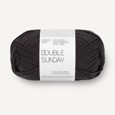 Ball of darkest grey yarn with a label on a white background