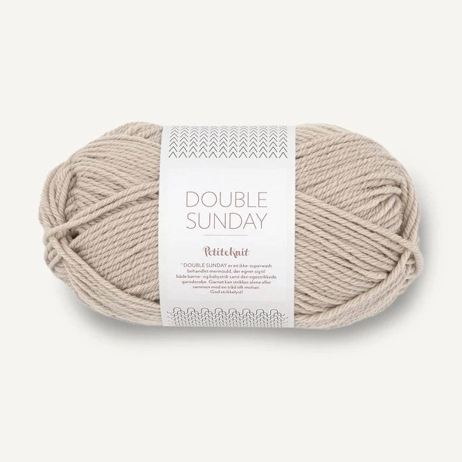 Ball of beige yarn with a label on a white background