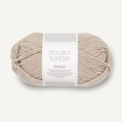Ball of beige yarn with a label on a white background