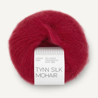 Red ball of yarn with a label on a white background