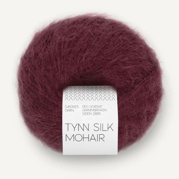 Ball of burgundy Tynn Silk Mohair yarn with a label on a white background