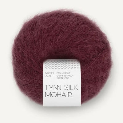 Ball of burgundy Tynn Silk Mohair yarn with a label on a white background
