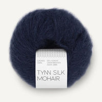 Navy blue skein of yarn with a label on a white background