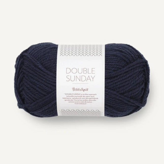Ball of deep navy blue yarn with a label on a white background