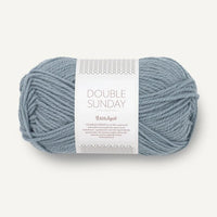 Ball of pale blue yarn with a label on a white background