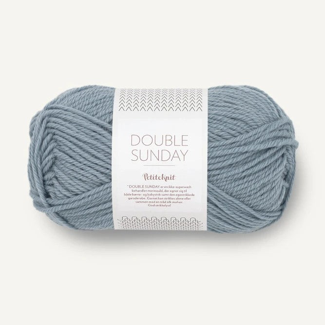 Ball of pale blue yarn with a label on a white background