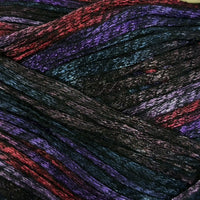Close-up of variegated yarn strands in a dark base with shimmering purple, red, and blue metallic highlights.