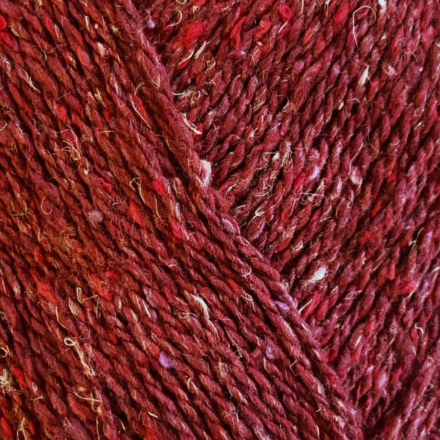 Close-up of red yarn with a textured tweed surface