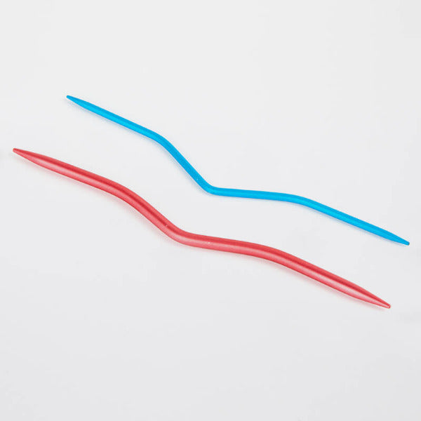 Two aluminum cable needles in red and blue on a white background