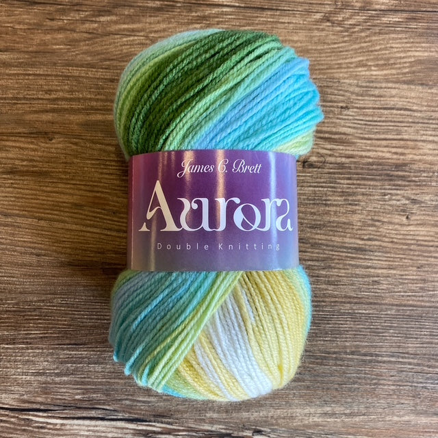 Multicolored skein of yarn with 'Aurora' label on a wooden surface