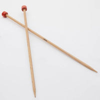Pair of crossed wooden needles on a white background