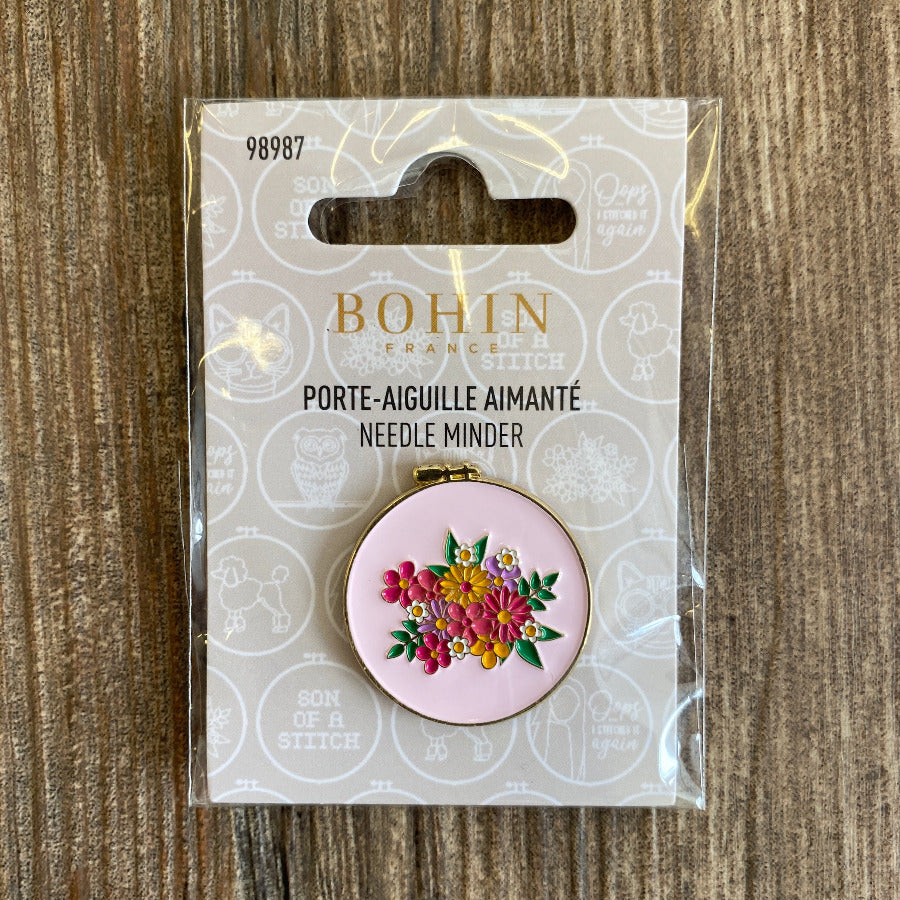 Bohin needle minder with floral design in packaging on a wooden surface