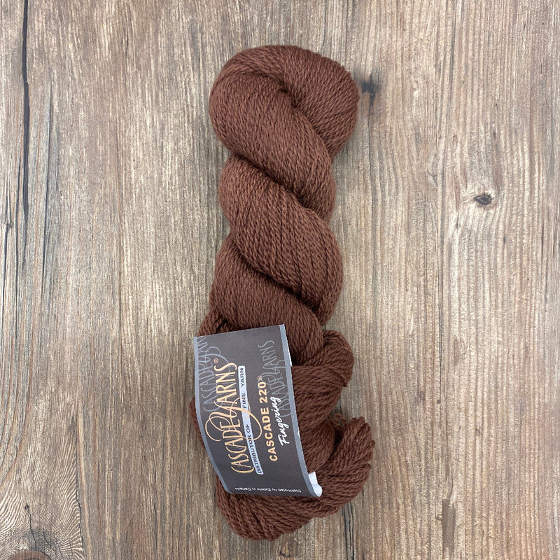 Brown skein of yarn with a label on a wooden surface