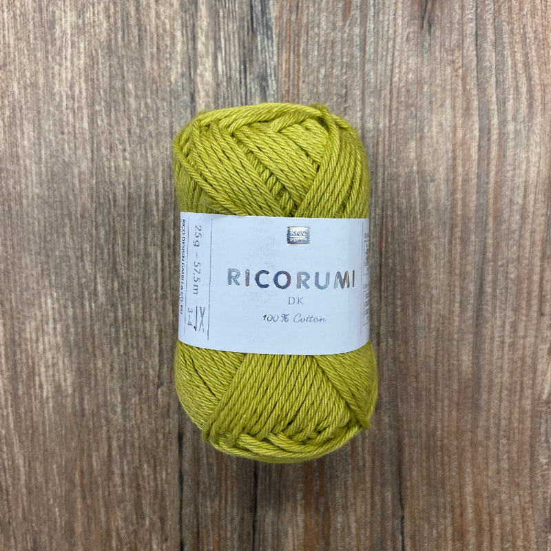 Ball of green yarn with a label on a wooden surface