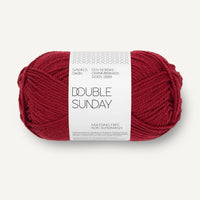 Ball of red yarn with a label on a white background