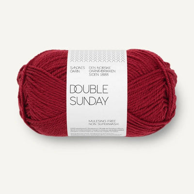 Ball of red yarn with a label on a white background