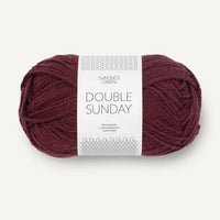 Ball of burgundy yarn with a label on a white background