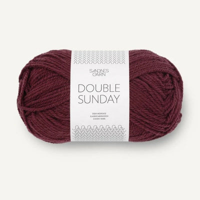 Ball of burgundy yarn with a label on a white background