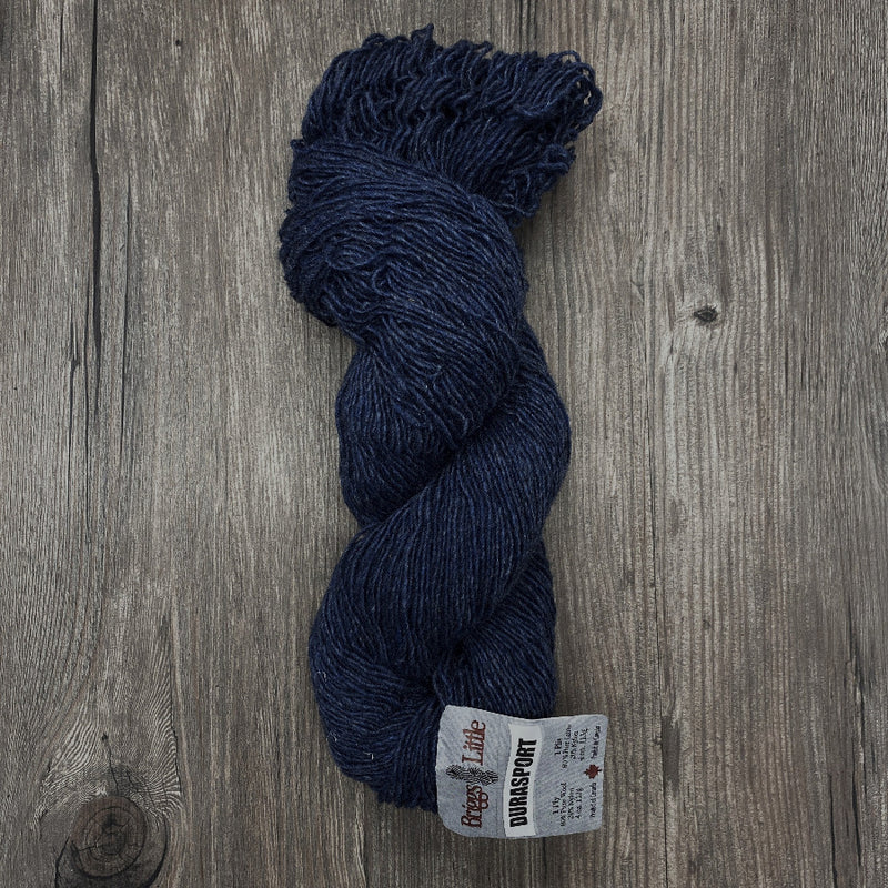 Blue skein of yarn with a label on a wooden surface