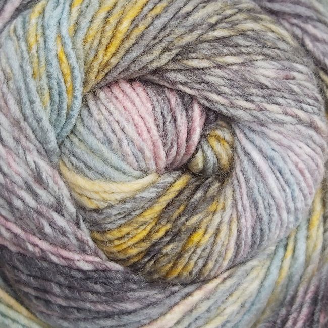 Close-up of a skein of multicolored yarn with shades of gray, pink, yellow, and blue.