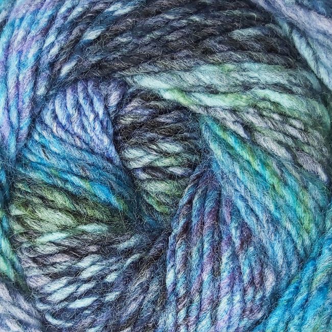 Close-up of a skein of multicolored yarn with shades of blue, navy, green, and purple.