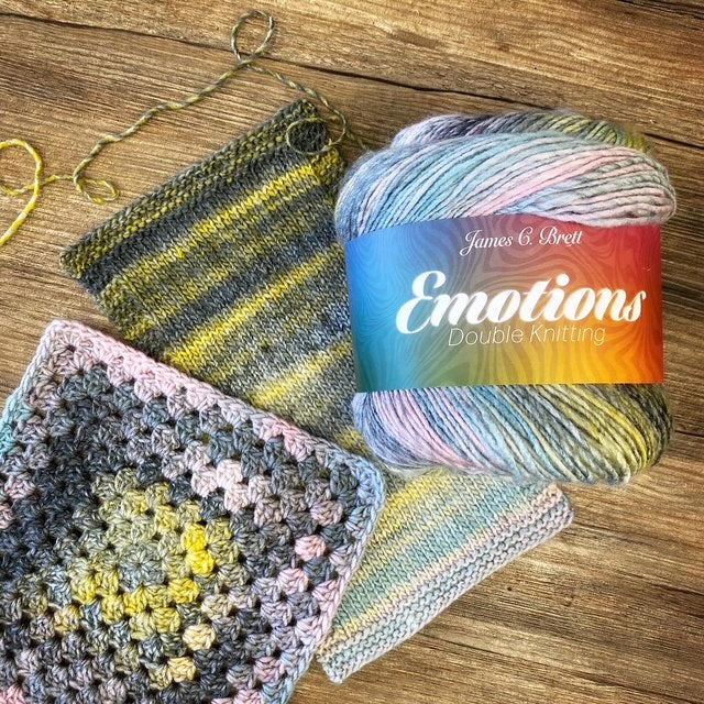Ball of yarn with 'Emotions' label and a knitted and crocheted square on a wooden surface