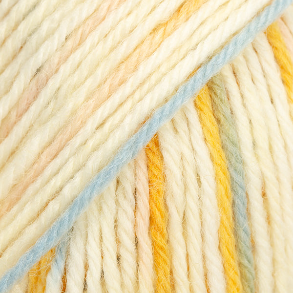 Close-up of multicolored yarn in mostly cream, with mustard and blue-grey sections