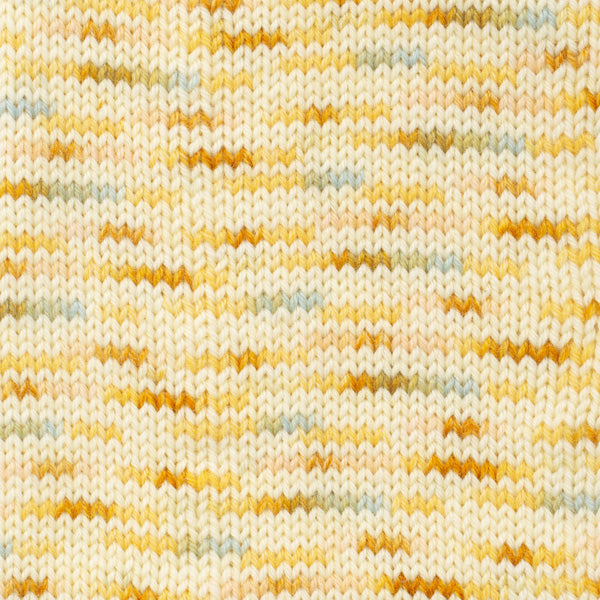 Close-up of knit fabric with a pattern of cream, mustard, and grey 