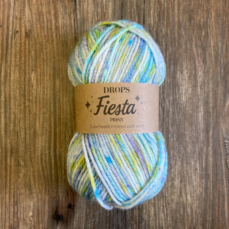 Colorful skein of yarn with a 'DROPS Fiesta' label on a wooden surface
