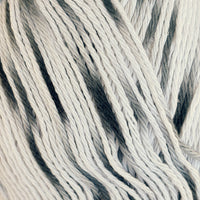 Close-up of white cotton yarn with soft black speckles