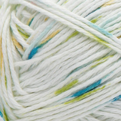 Close-up of a white ball of yarn with blue, yellow, and green speckles.