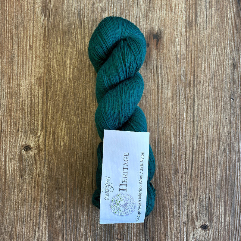 Teal skein of yarn with a label on a wooden surface