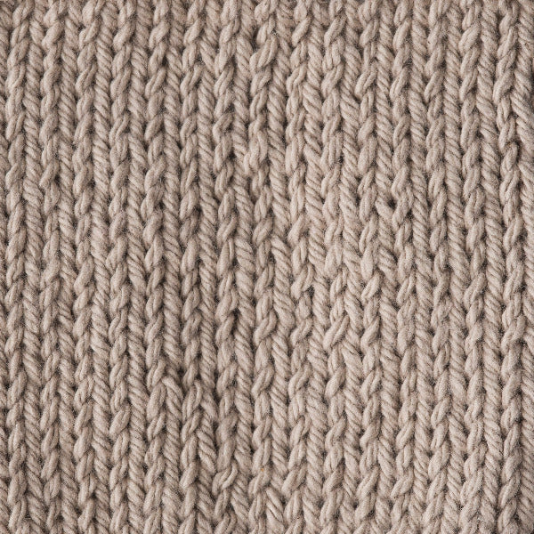 Close-up of a textured beige knitted fabric 