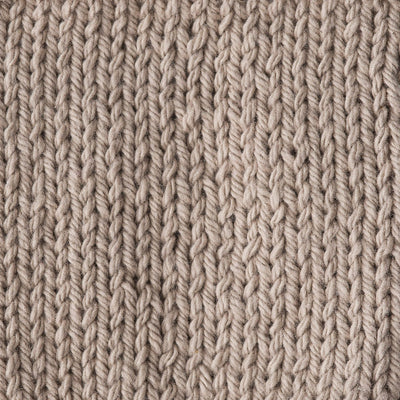 Close-up of a textured beige knitted fabric 