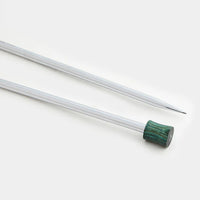Close up view of shiny silver knitting needles with a green wood end on them on a white background