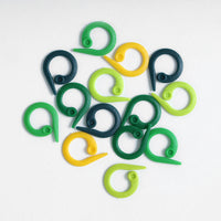Set of green and yellow plastic split ring markers on a white background