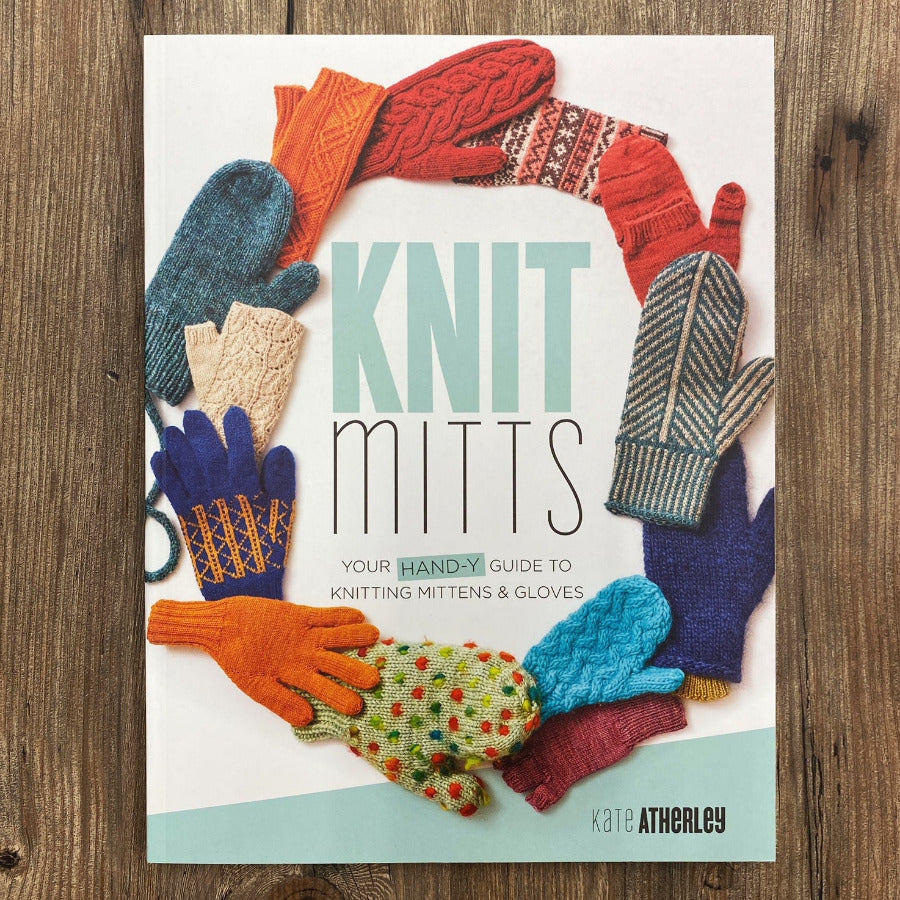 Book cover of 'Knit Mitts' by Kate Atherley with colorful knitted mittens and gloves on a wooden surface.