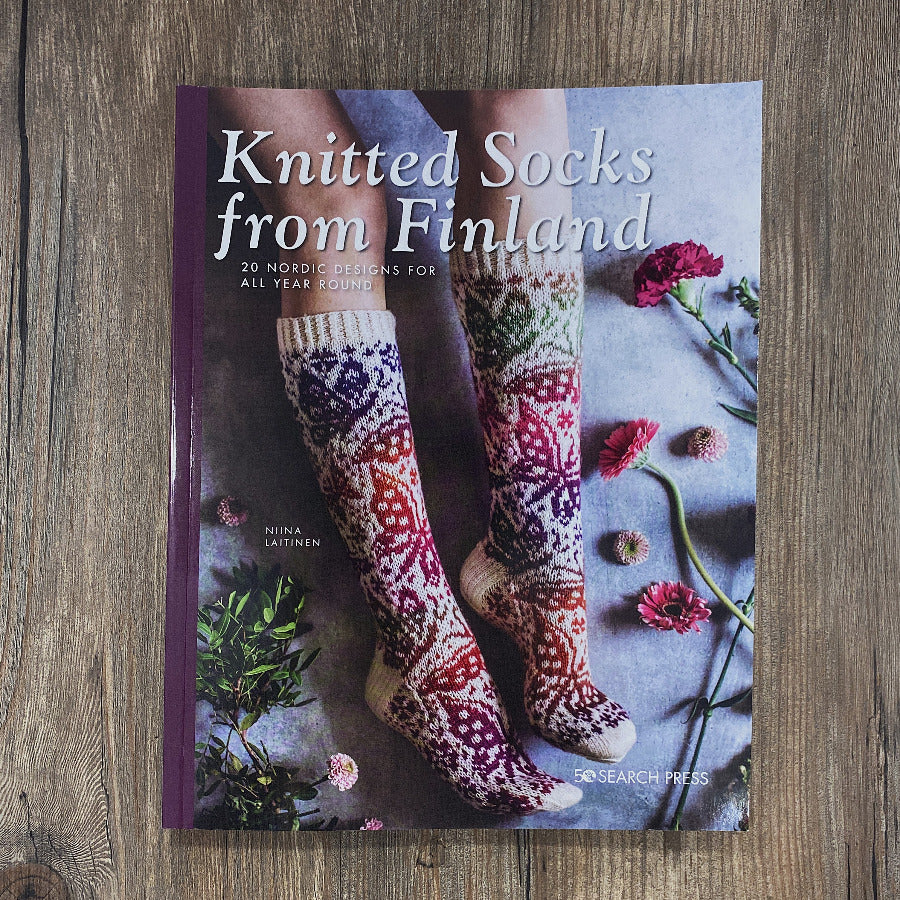 A book on knitted socks on a wood background