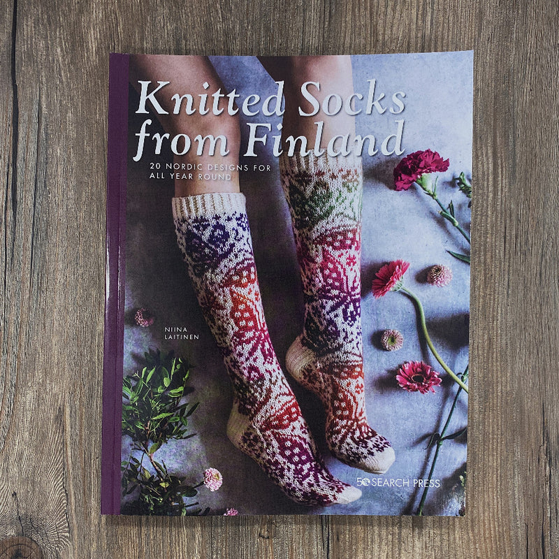 A book on knitted socks on a wood background