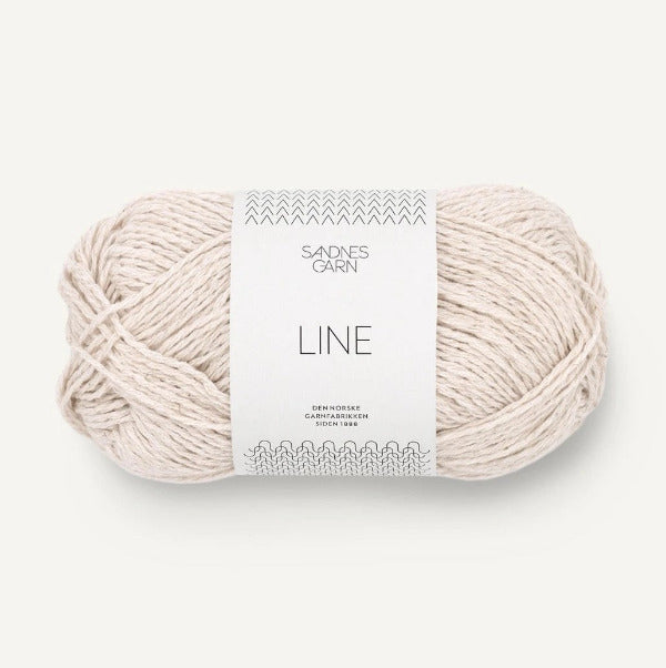 Ball of off white yarn with a label on a white background