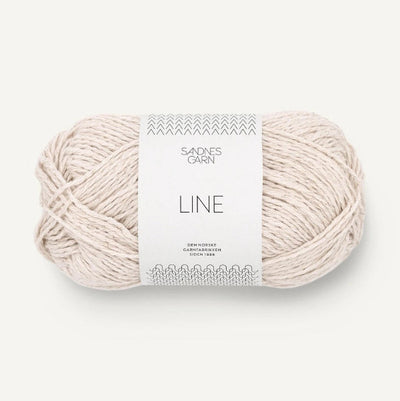 Ball of off white yarn with a label on a white background