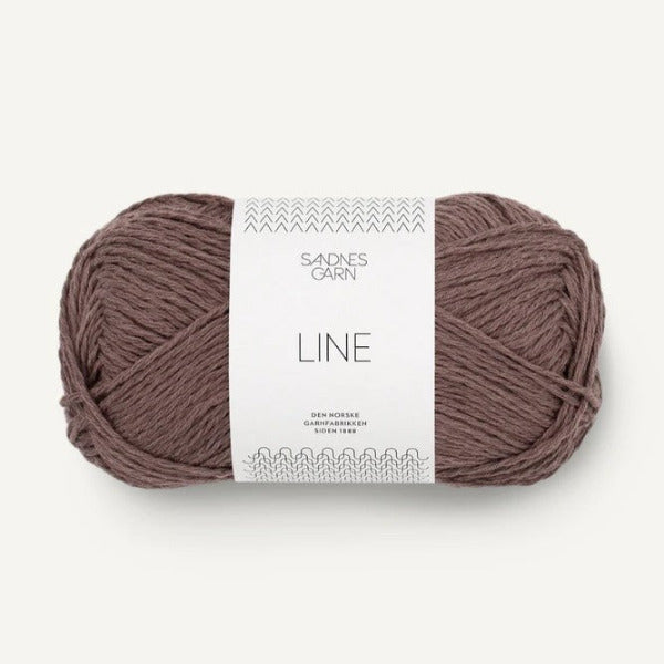 Ball of brown yarn with a label on a white background
