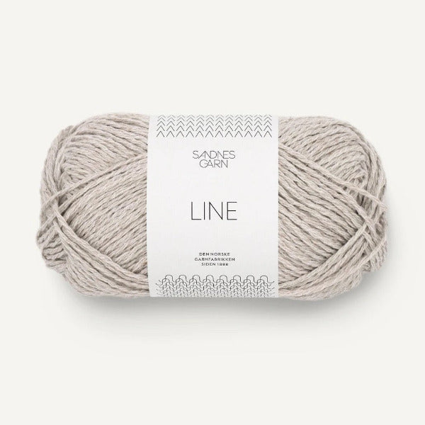 Ball of pale grey yarn with a label on a white background