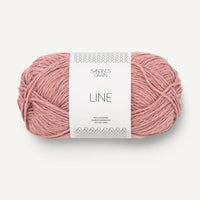 Ball of light pink yarn with a label on a white background